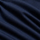 A close-up of dark navy blue fabric with a subtle woven geometric pattern and soft folds.