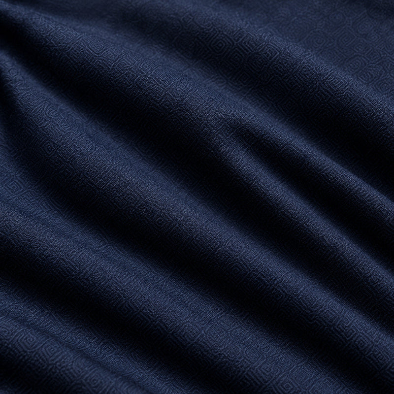 A close-up of dark navy blue fabric with a subtle woven geometric pattern and soft folds.