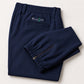A pair of navy blue athletic golf jogger pants folded neatly on a light beige background. The pants feature an elastic waistband, a zippered pocket on the left leg, and the brand name 'ELUSIV' embroidered in white and green above the back left pocket.