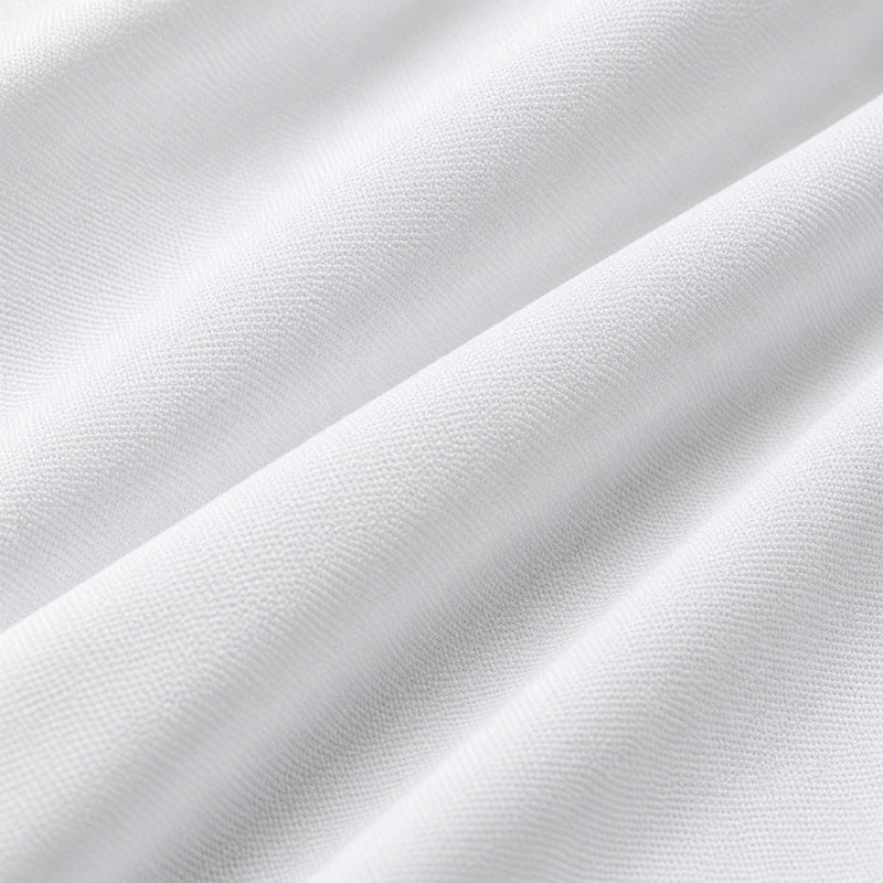 A close-up of white textured fabric with soft diagonal folds and a fine woven surface.